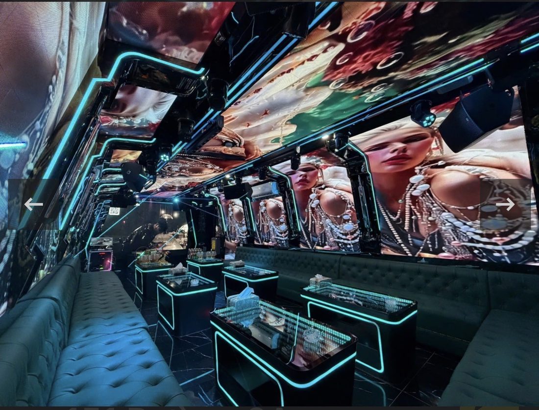 DRAGON PALACE KTV 长条形包厢，墙面与天花全是 LED 屏放珠宝人像画面，青绿灯带勾边，墨绿绒面钮扣长沙发