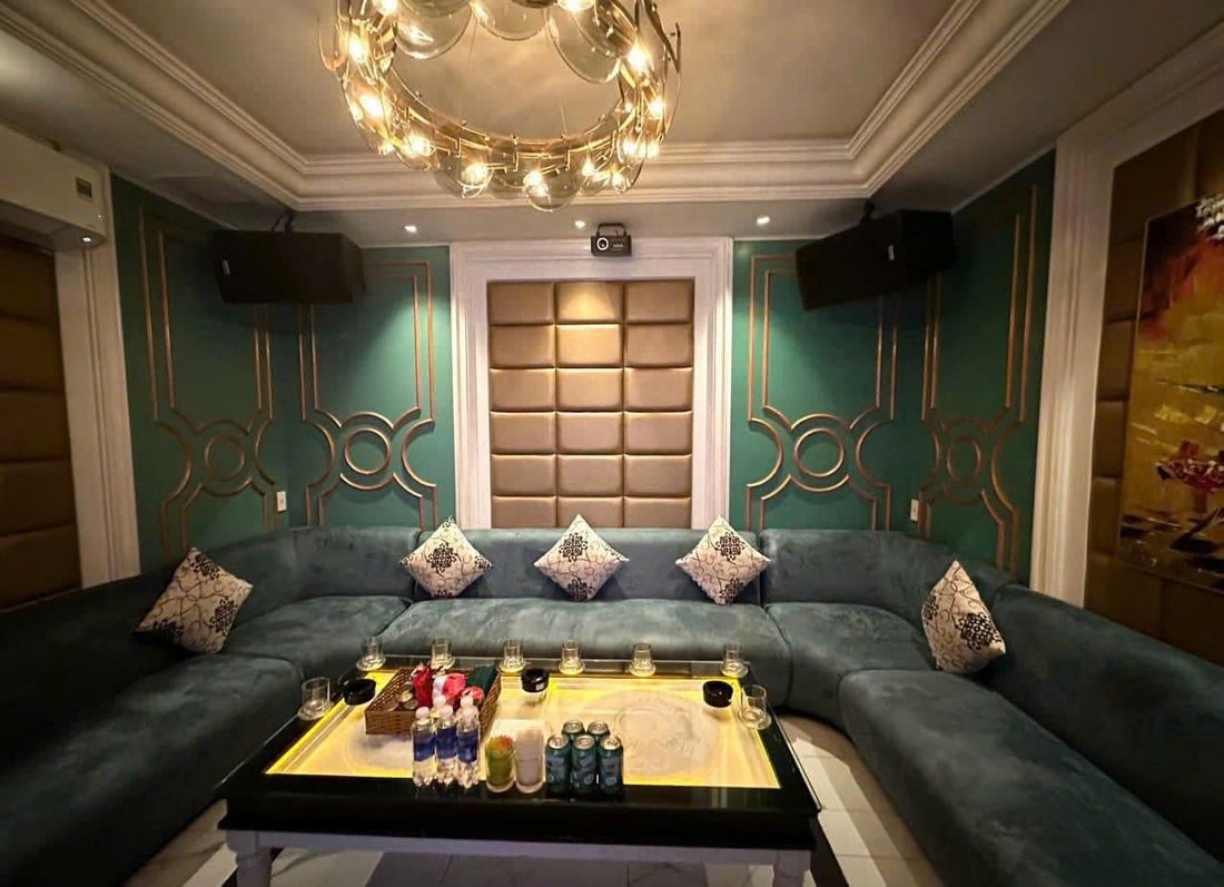 NEW 127 KTV 墨绿丝绒 U 型长卡座包厢，墨绿护墙板压香槟金圆环线条与金色圆环水晶吊灯